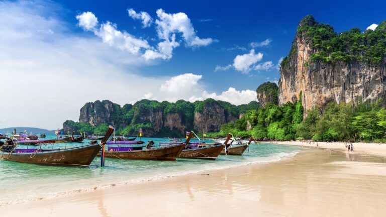 Playa de Railay en Krabi con barcas de cola larga y acantilados de roca caliza