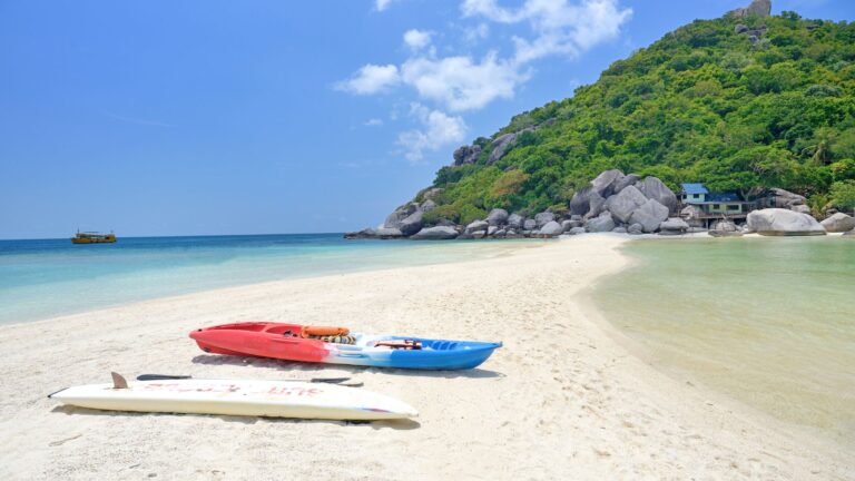 Playa de arena blanca con kayaks en Koh Tao