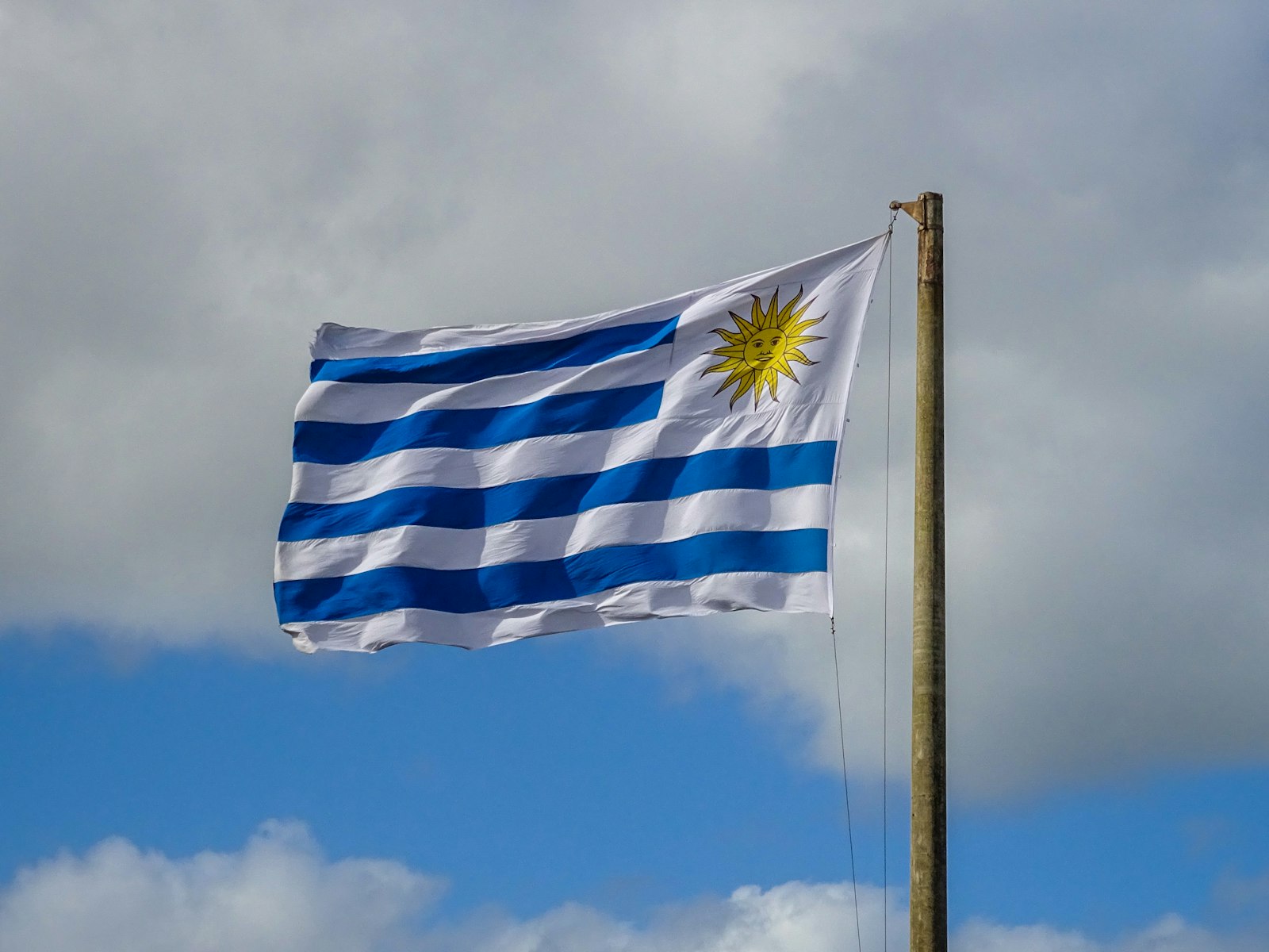 Bandera de Uruguay ondeando contra un cielo azul