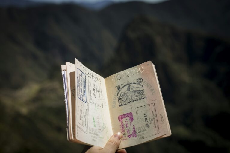 Mano sosteniendo un pasaporte abierto con sellos de viaje