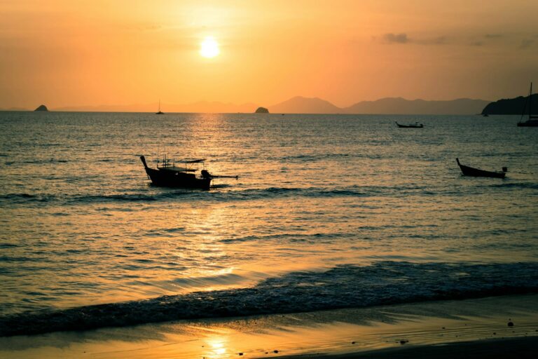 Atardecer en la playa de Railay con una barca de cola larga, en Krabi