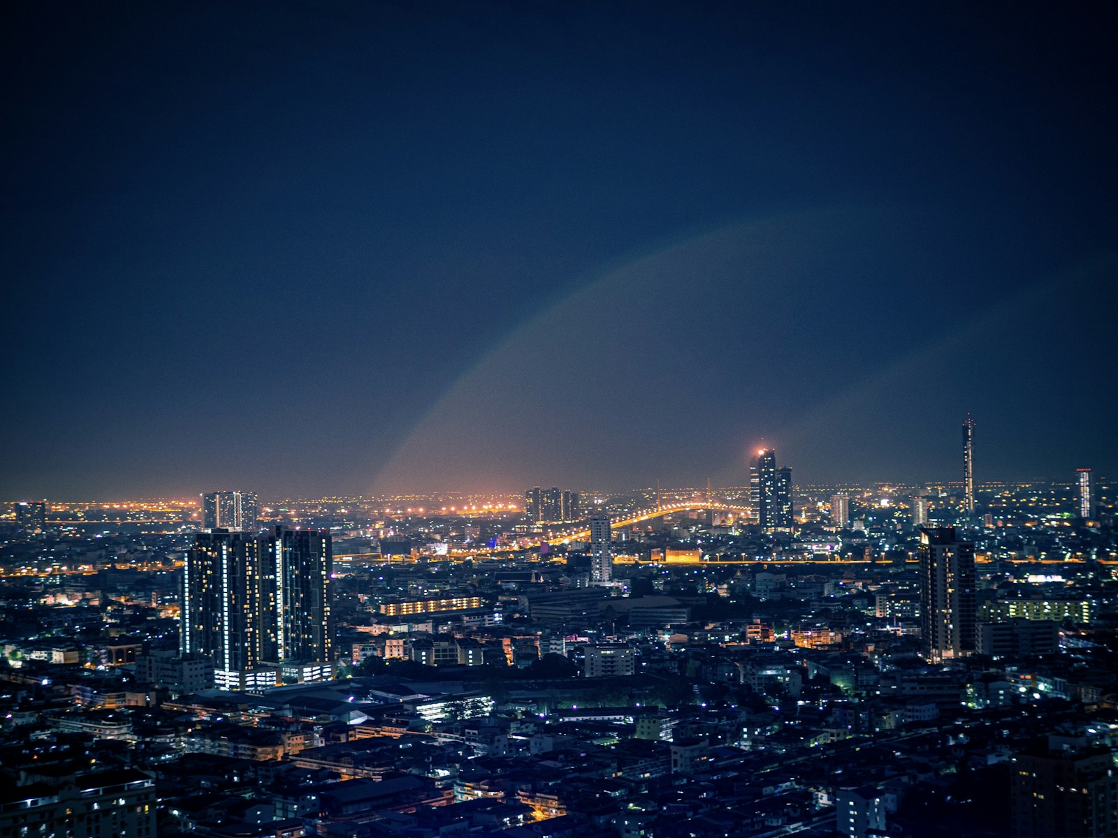 Vista nocturna de Bangkok iluminada desde una azotea