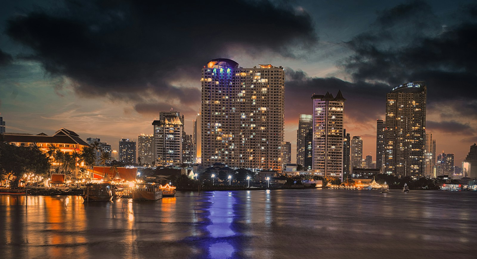 El skyline de Bangkok de noche reflejado en el río Chao Phraya