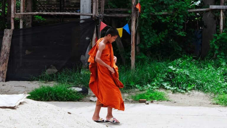 Joven monje budista con túnica naranja en Nong Khai