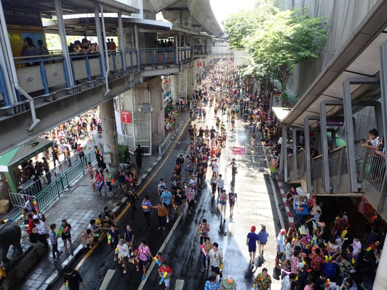 Calle de Bangkok llena de gente bajo el tren elevado durante la fiesta del agua de Songkran