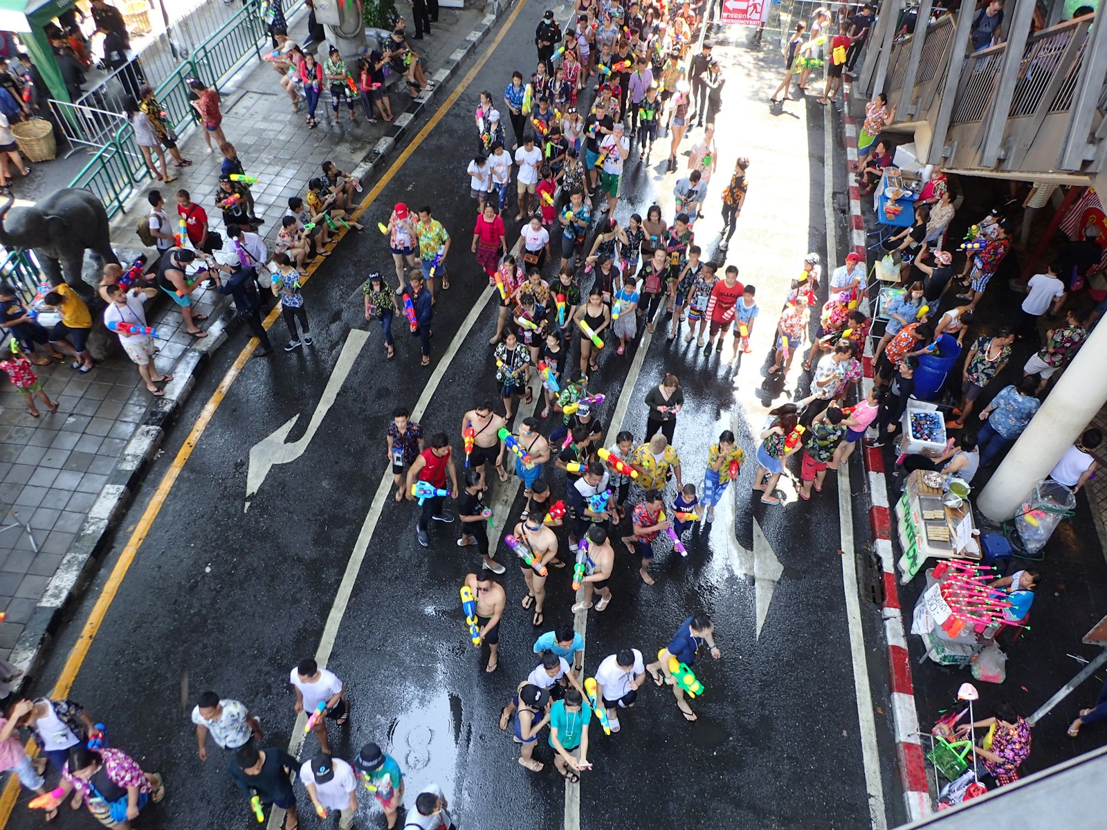 Multitud celebrando Songkran con pistolas de agua en una calle de Bangkok