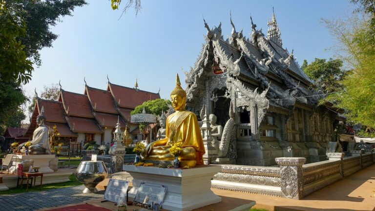 Imagen dorada de Buda ante el templo de plata de Chiang Mai
